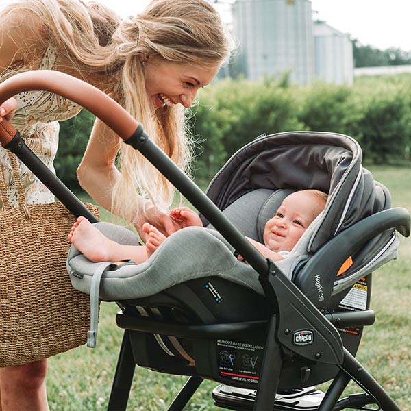 Infant seated in a Chicco KeyFit 35 ClearTex car seat secured to a stroller with a parent holding the handle