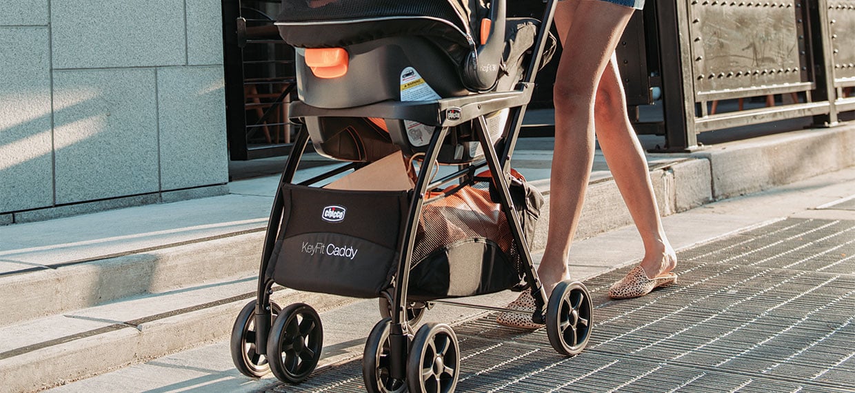 Chicco frame stroller with infant car seat on a city sidewalk