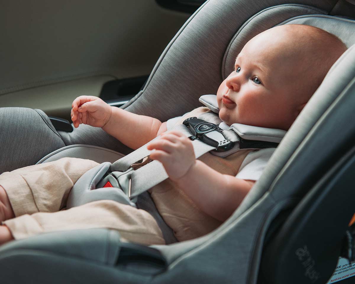 Infant secured in a Chicco infant car seat inside a vehicle