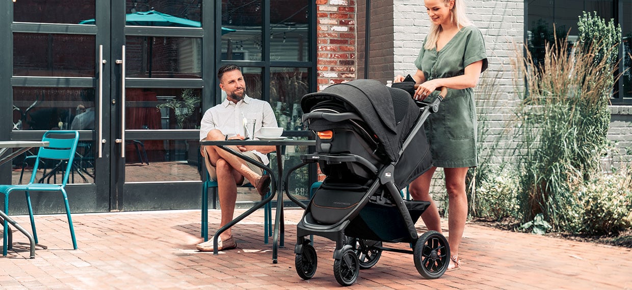 Woman pushing a Chicco full-size stroller on an outdoor patio