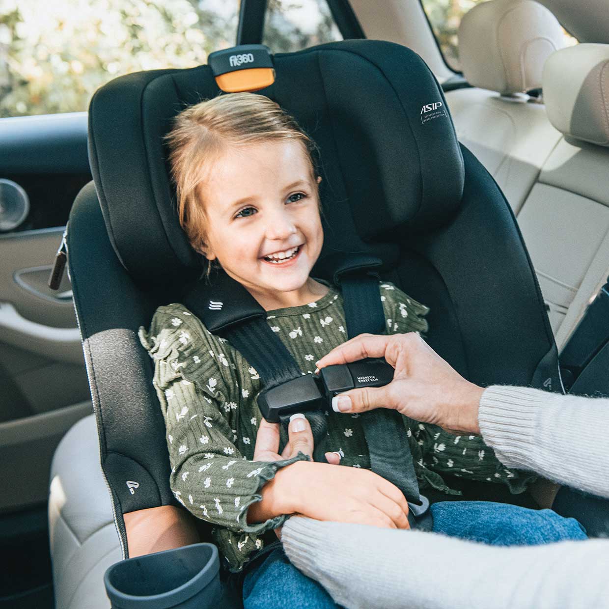 Mother buckling child in to a Chicco Fit360 Zip Car Seat